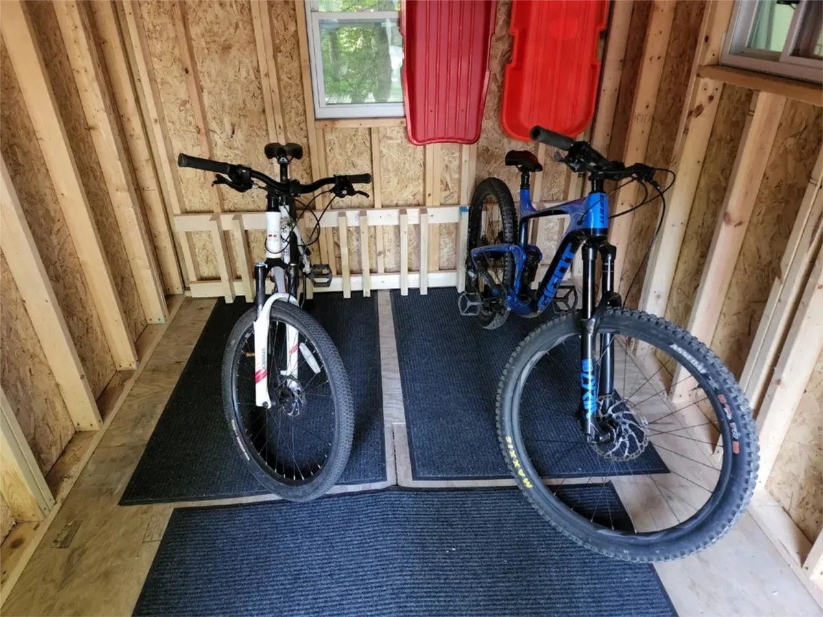 A practical, organized interior space dedicated to storage shows two bicycles, storage shelves, and red sleds. The area is designed for easy access to gear supporting both winter and summer adventures, underlining the property's readiness for active guests.